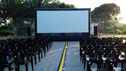 patio de butacas de cine de verano, pantalla y sillas verdes de plástico
